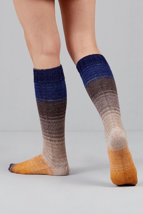 Knitted socks in indigo, grey, and yellow tones from Urth Yarns in the Gusto line