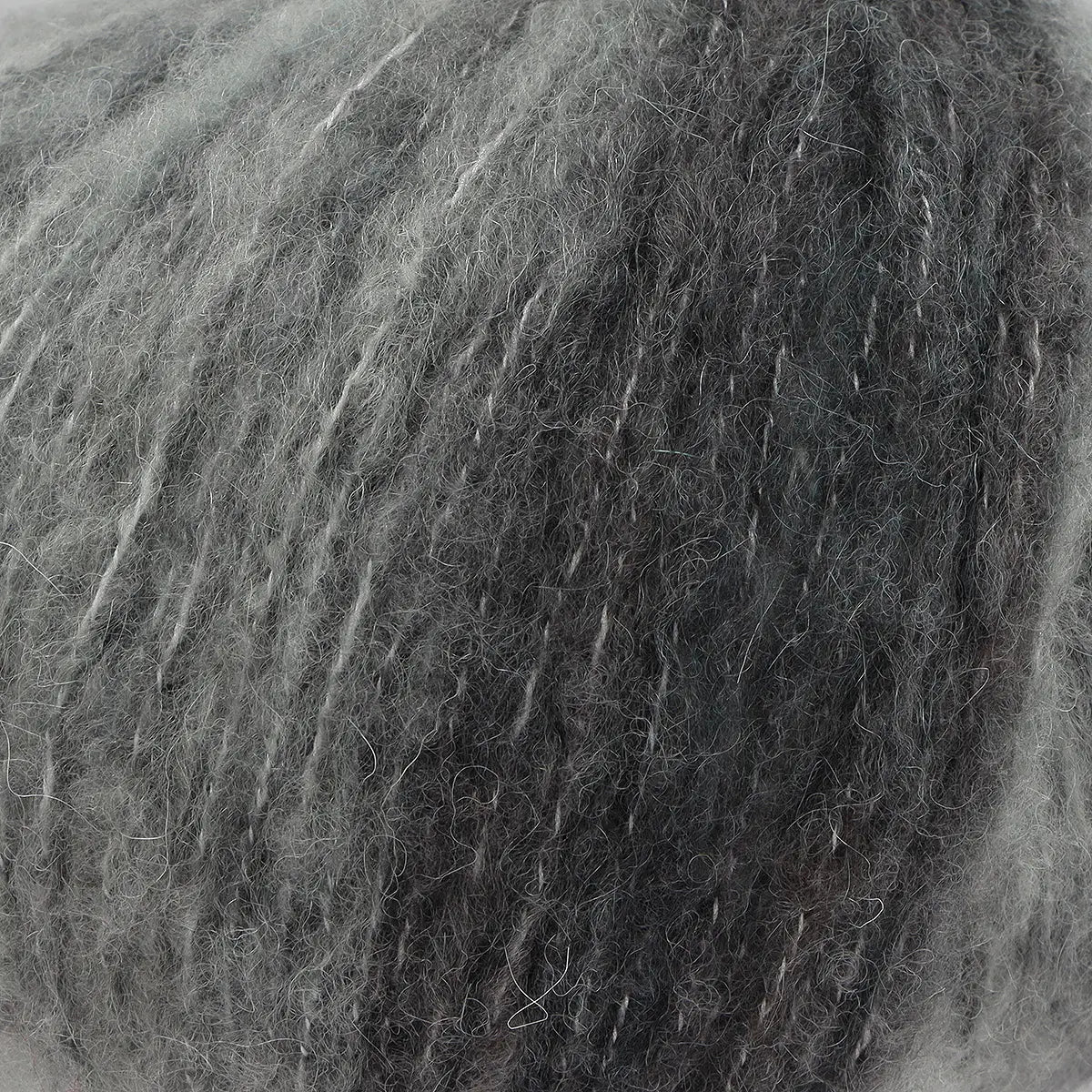 A close-up of acrylic, mohair, polyester, and wool yarn in grey tones