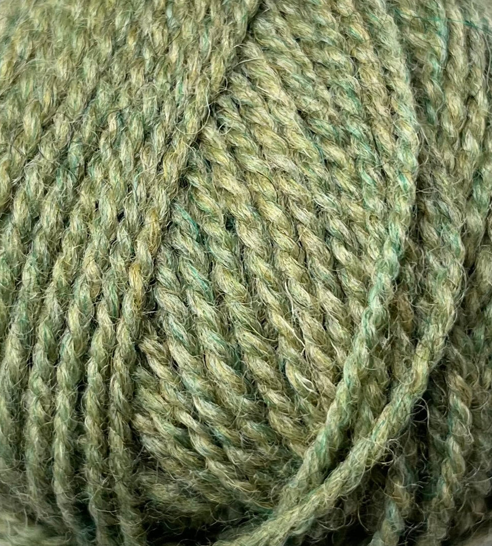 An up-close skein of Haynes Creek Heathers DK yarn in a pale green color.