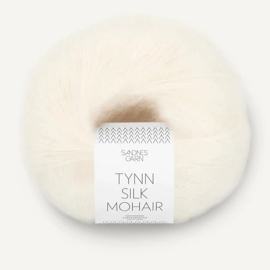 A ball of Tynn Silk Mohair yarn in a white color with a 'Tynn Silk Mohair' label from Sandnes Garn