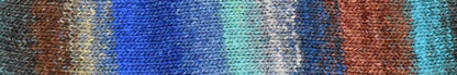 Knitted fabric swatch with a gradient of rust, teal, and blue colors.