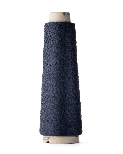A spool of navy blue merino wool fingering weight yarn.