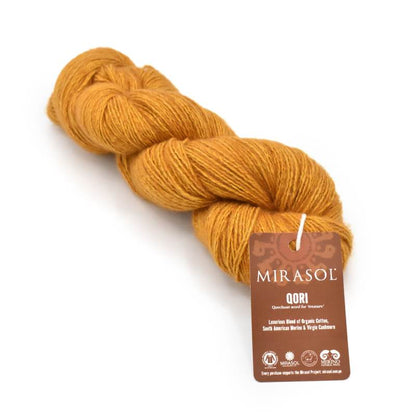 Mustard yellow skein of organic cotton yarn labeled 'Qori' by Mirasol. 