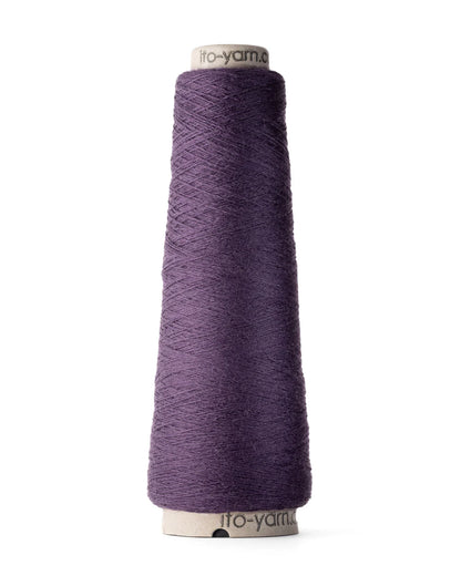 A spool of blackberry purple merino wool fingering weight yarn.