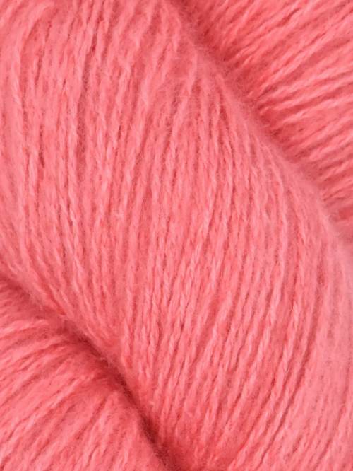 Close-up image of a skein of sumaq pink colored cotton yarn.