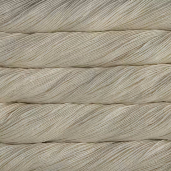 A close-up of cream-colored twisted yarn strands stacked horizontally, showing the texture and color of the fiber.