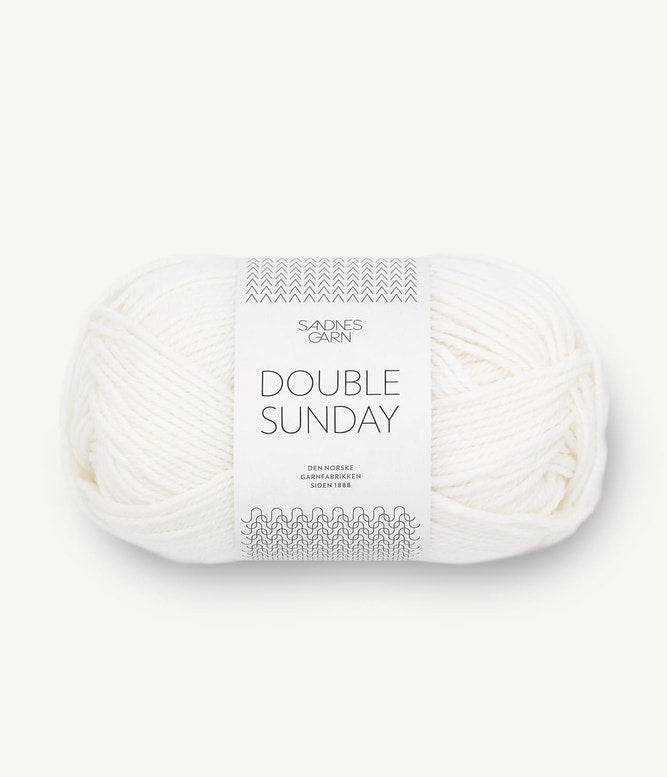 A ball of white coloured merino wool yarn labeled 'Double Sunday' by Sandnesgarn.