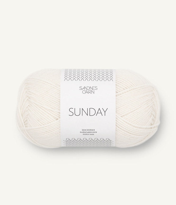 A ball of Sandnesgarn Sunday merino wool yarn in a white color, with packaging that includes the brand and product name.