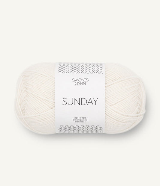 A ball of Sandnesgarn Sunday merino wool yarn in a white color, with packaging that includes the brand and product name.