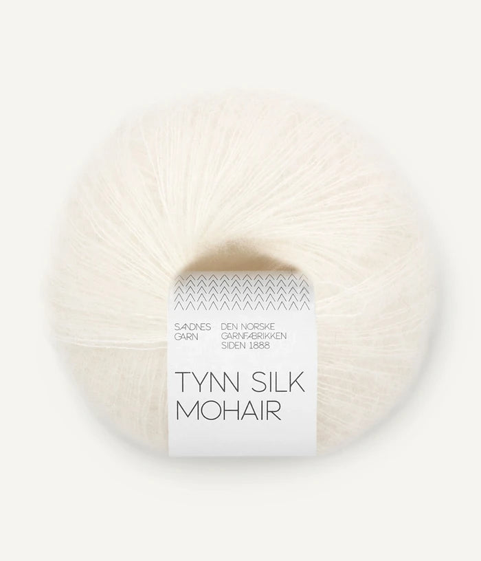 A ball of Tynn Silk Mohair yarn in an off  white color with a 'Tynn Silk Mohair' label from Sandnes Garn