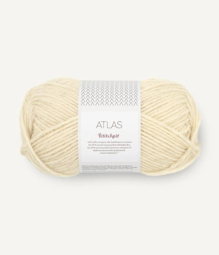 Ball of cream-colored yarn with a label on a white background