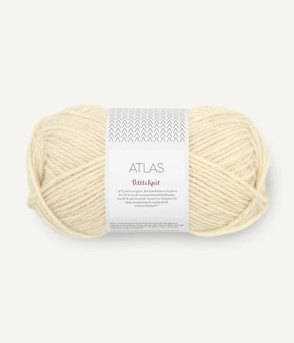 Ball of cream-colored yarn with a label on a white background