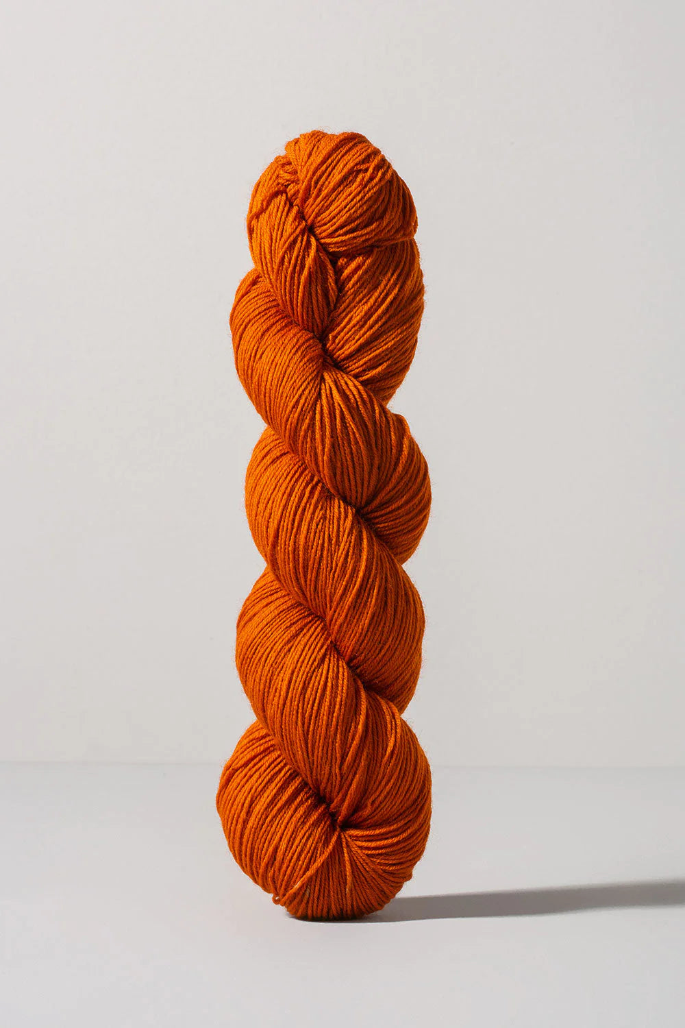 Dark orange skein of merino and nylon yarn from Urth