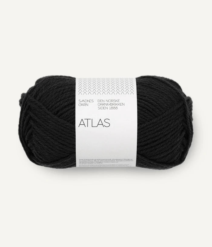 Black yarn ball with a white label on a white background