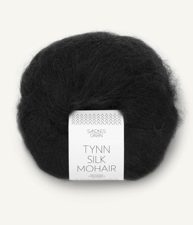 A ball of Tynn Silk Mohair yarn in a black color with a 'Tynn Silk Mohair' label from Sandnes Garn