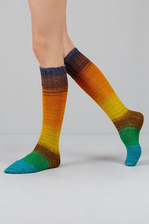 Knitted socks with blue, green, yellow, orange, brown, and purple tones from Urth Yarns in the Gusto line