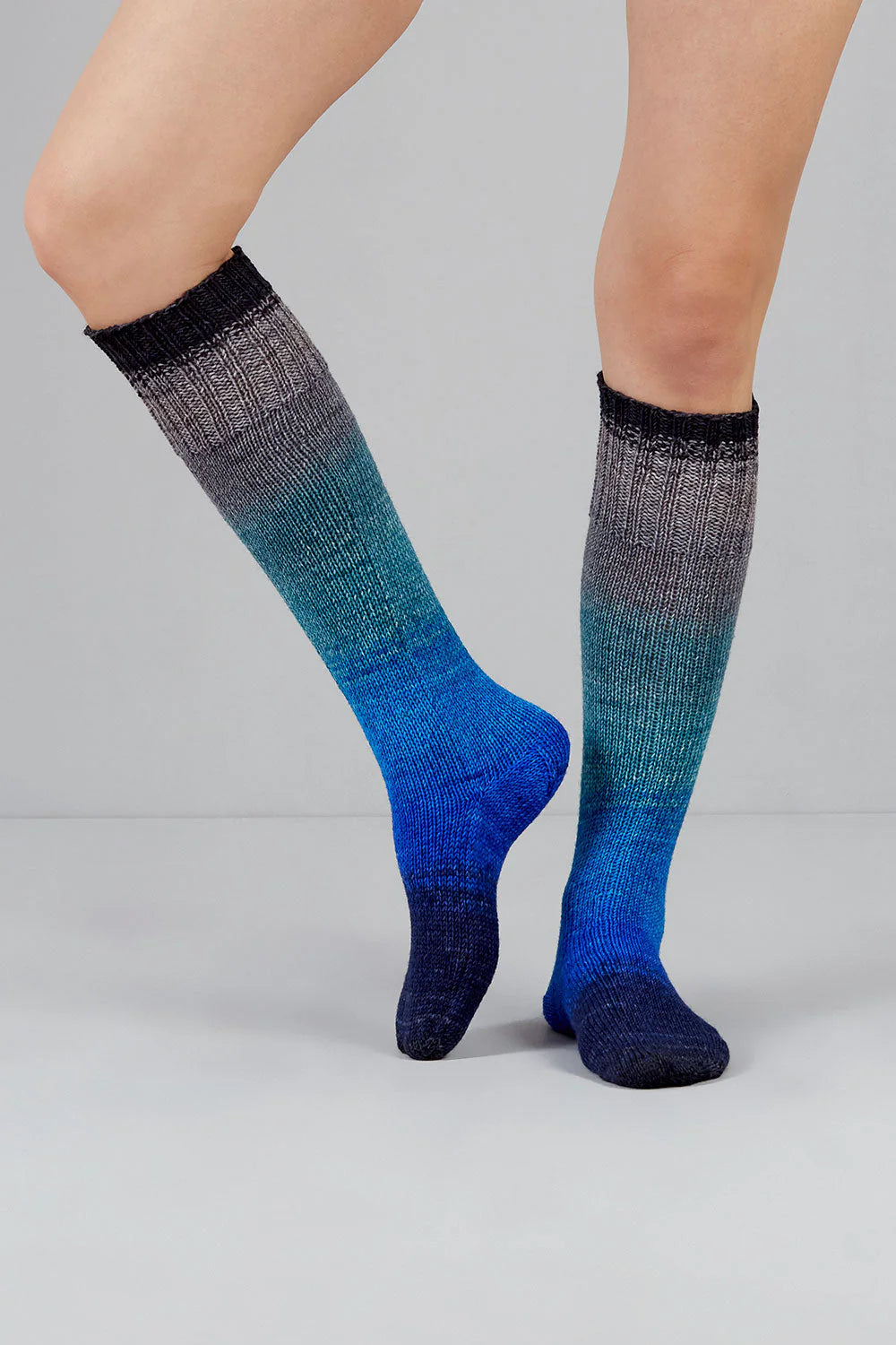 Knitted socks in blue and grey tones from Urth Yarns in the Gusto line
