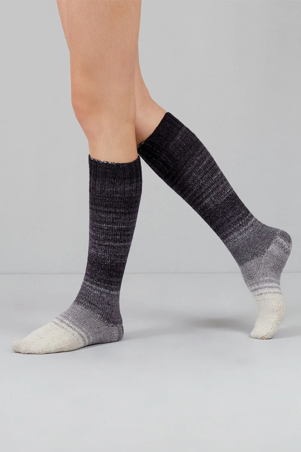 Knitted socks in grey and white tones from Urth Yarns in the Gusto line