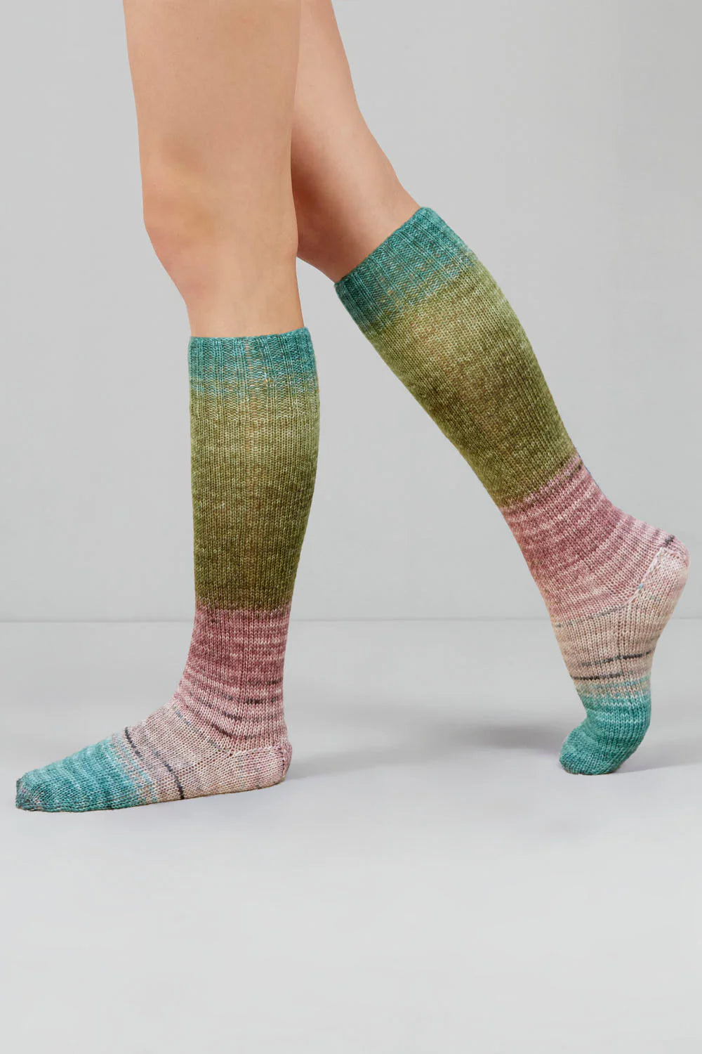 Knitted socks in blue, beige, and green tones from Urth Yarns in the Gusto line