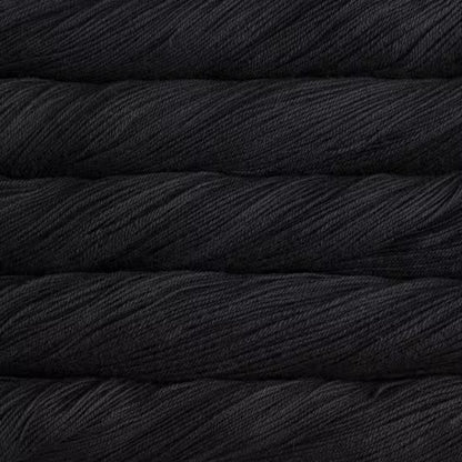 A close-up texture shot of stacked black yarn skeins, showing the twisted plies and soft sheen of the fiber.