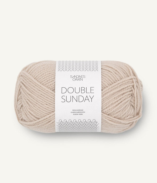A ball of beige coloured merino wool yarn labeled 'Double Sunday' by Sandnesgarn.