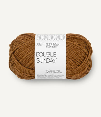 A ball of brown-gold coloured merino wool yarn labeled 'Double Sunday' by Sandnesgarn.