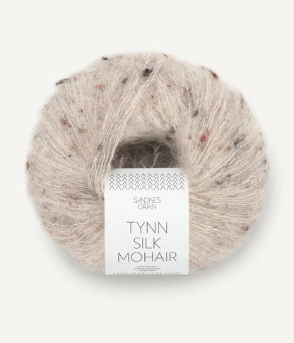 A ball of Tynn Silk Mohair yarn in a beige tweed color with a 'Tynn Silk Mohair' label from Sandnes Garn