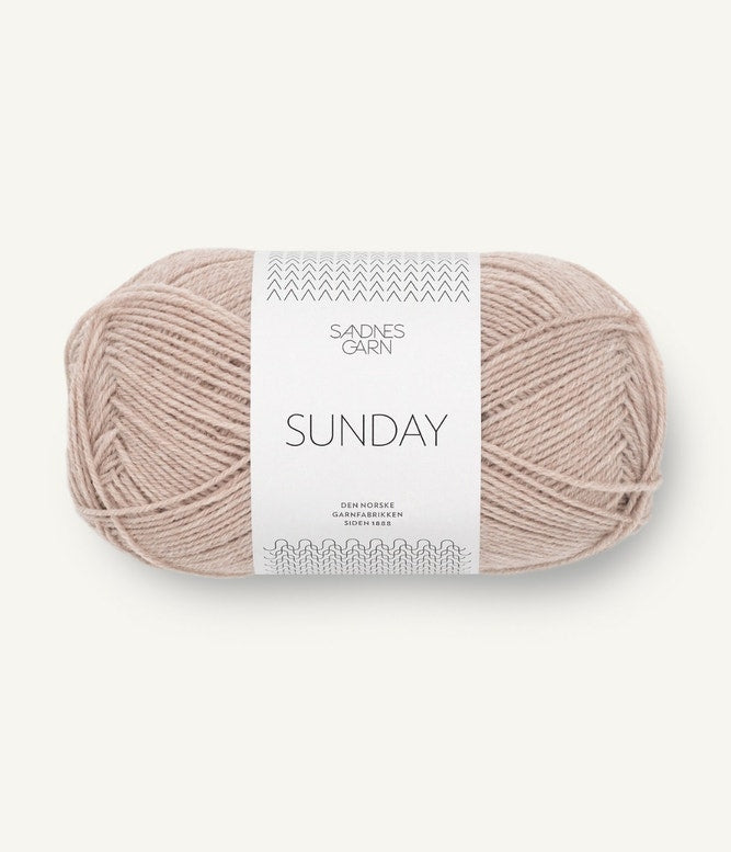 A ball of Sandnesgarn Sunday merino wool yarn in a beige color, with packaging that includes the brand and product name.
