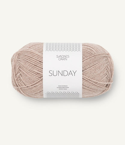 A ball of Sandnesgarn Sunday merino wool yarn in a beige color, with packaging that includes the brand and product name.