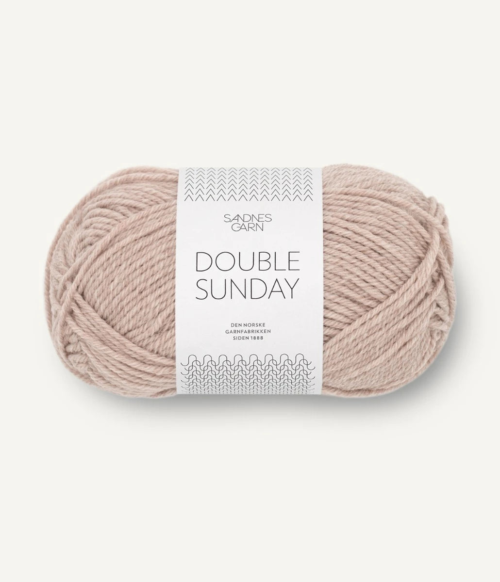 A ball of mottled beige coloured merino wool yarn labeled 'Double Sunday' by Sandnesgarn.