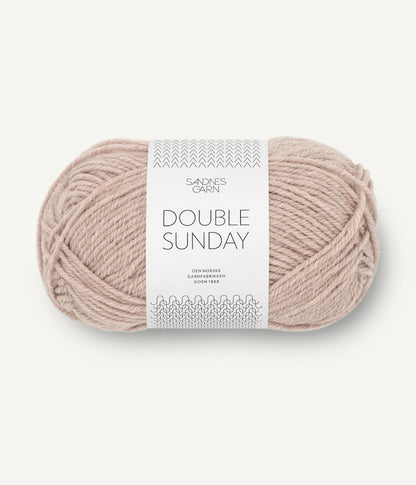 A ball of mottled beige coloured merino wool yarn labeled 'Double Sunday' by Sandnesgarn.