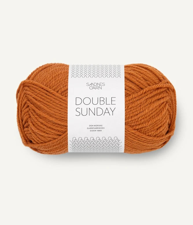 A ball of orange coloured merino wool yarn labeled 'Double Sunday' by Sandnesgarn.