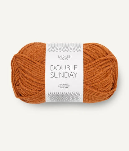 A ball of orange coloured merino wool yarn labeled 'Double Sunday' by Sandnesgarn.