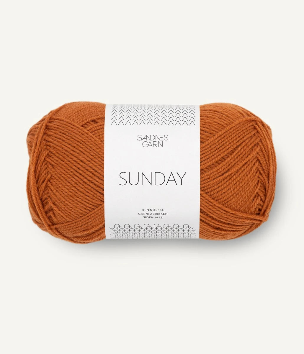 A ball of Sandnesgarn Sunday merino wool yarn in an orange color, with packaging that includes the brand and product name.