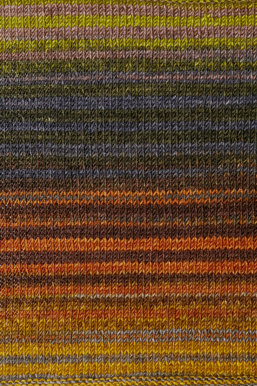 a knitted swatch of merino yarn with orange, grey, and yellow tones from Urth yarns