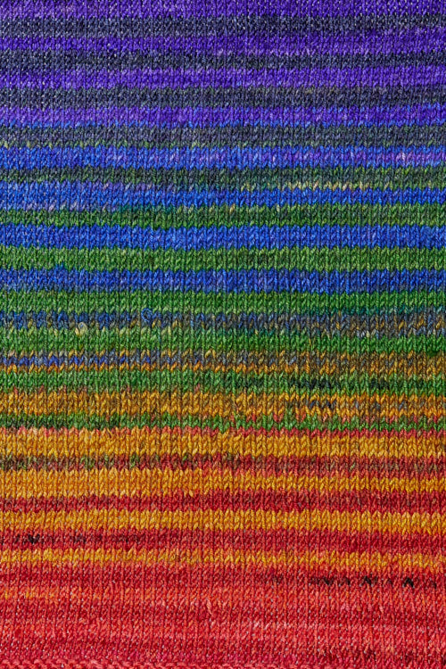 a knitted swatch of merino yarn with rainbow tones from Urth yarns