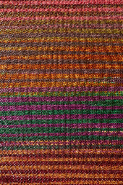 a knitted swatch of merino yarn with orange, green, and purple tones from Urth yarns
