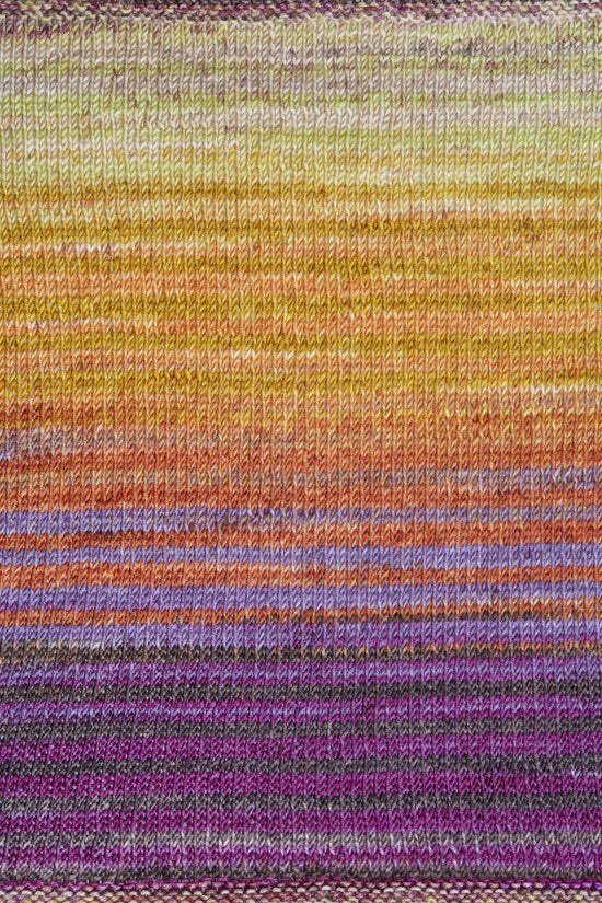 a knitted swatch of merino yarn with orange, purple, and yellow tones from Urth yarns
