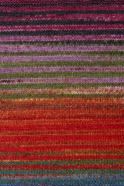 a knitted swatch of merino yarn with orange, green, pink, and blue tones from Urth yarns