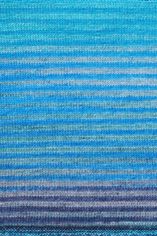a knitted swatch of merino yarn with blue, and purple tones from Urth yarns