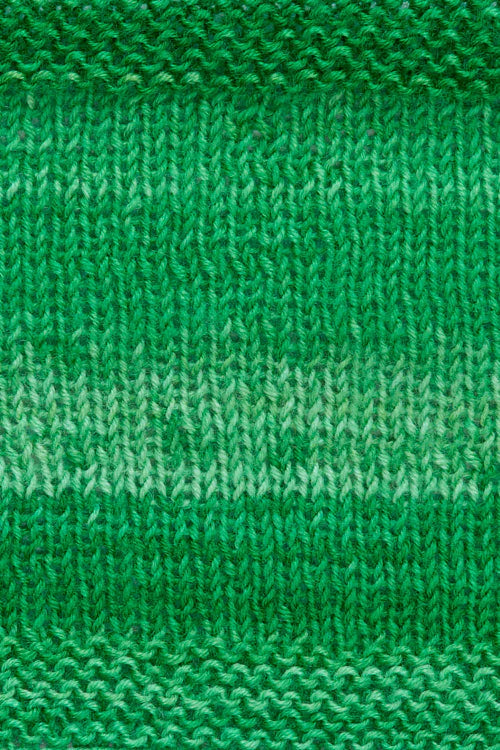 A knitted swatch of green tonal superwash merino wool yarn from Urth