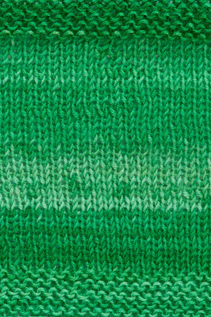 A knitted swatch of green tonal superwash merino wool yarn from Urth