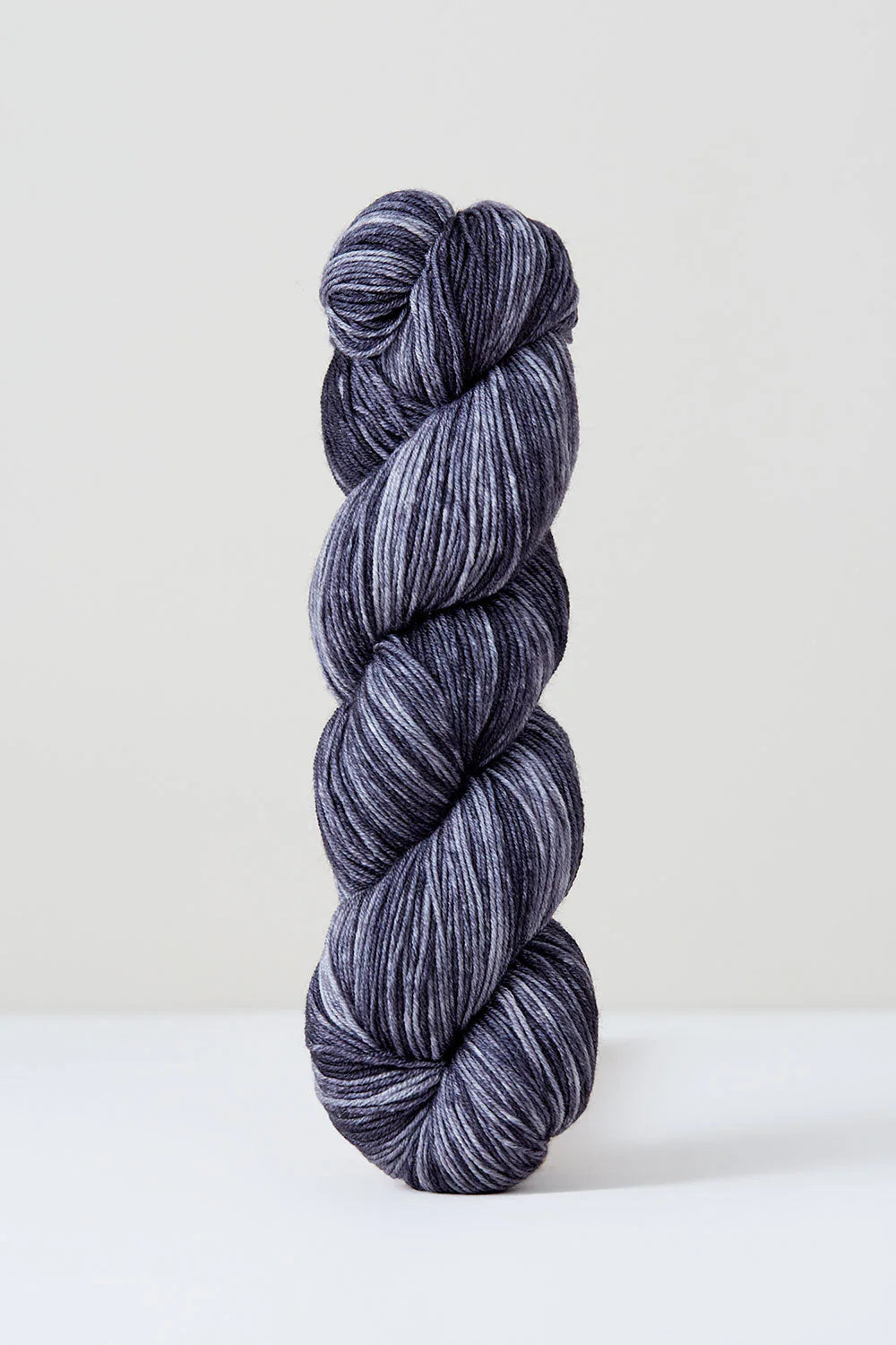 A skein of grey tonal superwash merino wool yarn from Urth