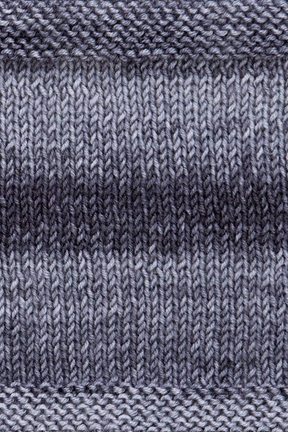 A knitted swatch of grey tonal superwash merino wool yarn from Urth