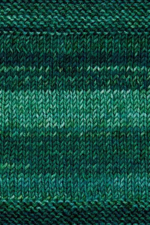 A knitted swatch of deep green tonal superwash merino wool yarn from Urth