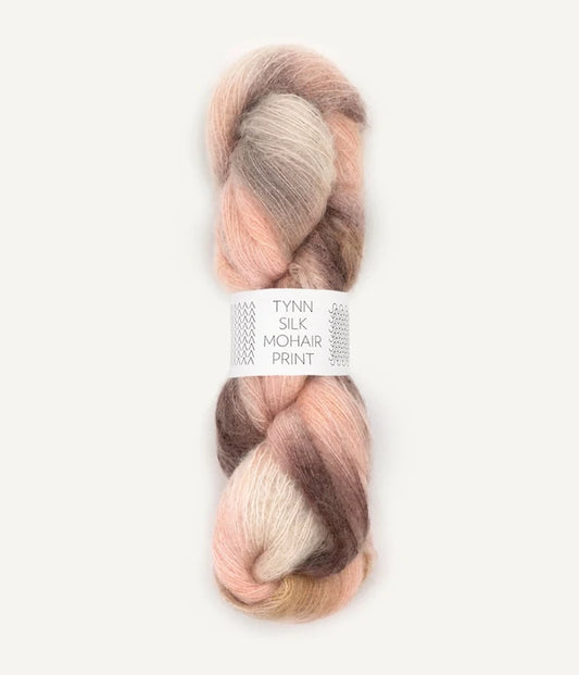 A skein of Tynn Silk Mohair print yarn in a blend of beige, brown, and pink colors