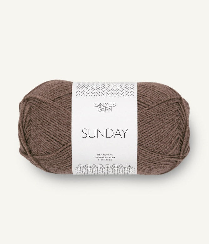 A ball of Sandnesgarn Sunday merino wool yarn in a brown color, with packaging that includes the brand and product name.