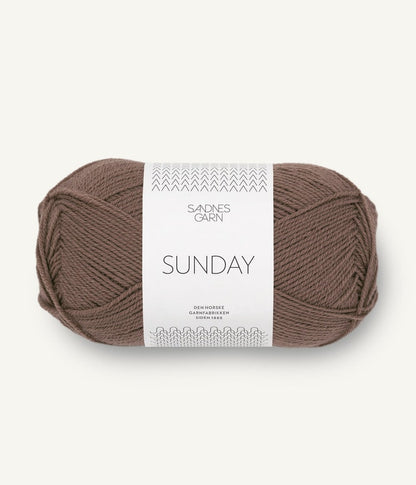 A ball of Sandnesgarn Sunday merino wool yarn in a brown color, with packaging that includes the brand and product name.