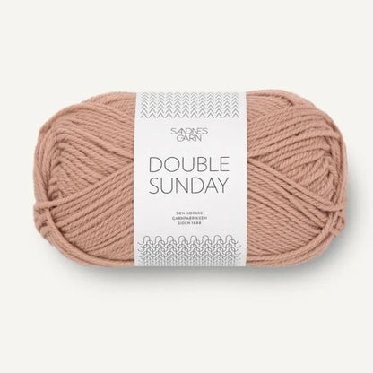 A ball of peach coloured merino wool yarn labeled 'Double Sunday' by Sandnesgarn.