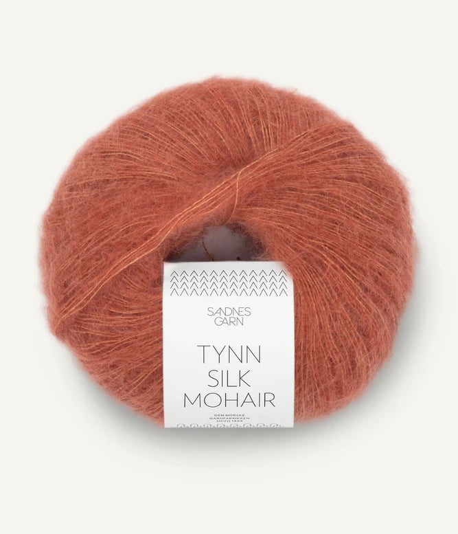 A ball of Tynn Silk Mohair yarn in a copper color with a 'Tynn Silk Mohair' label from Sandnes Garn